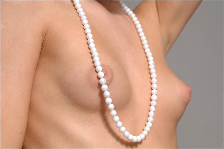 жемчужные бусы на голой женской груди